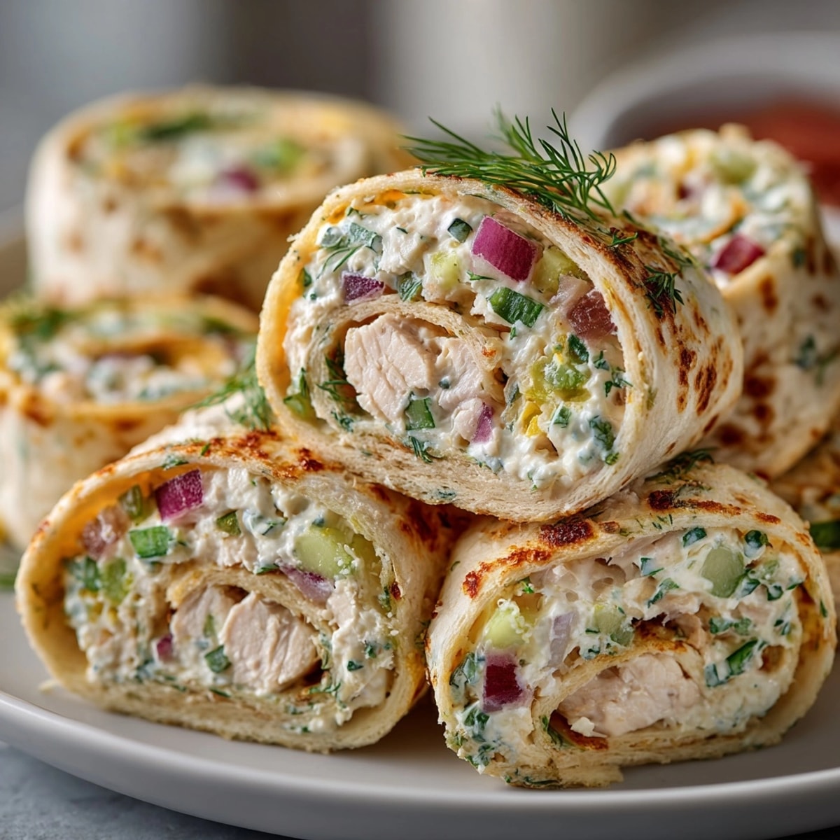 Dill pickle chicken pinwheel wraps showcasing creamy chicken, crunchy pickles, and a flaky tortilla, ready to eat.