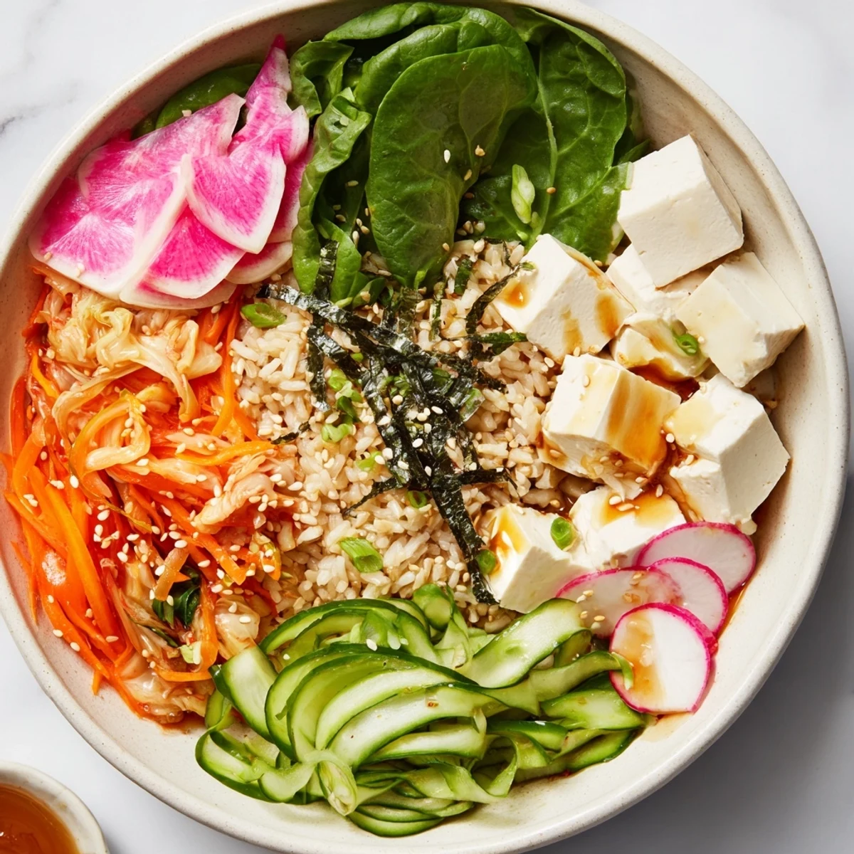 Colorful fermented vegetable bowl topped with tangy kimchi, fresh avocado, and grains.  