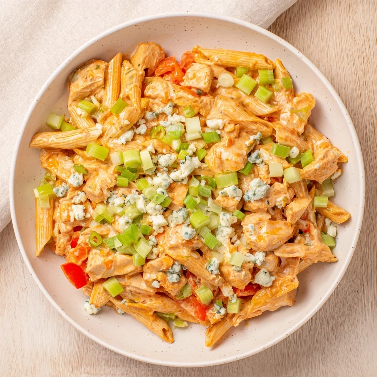 Savory Buffalo Chicken Pasta Skillet bubbling in a pan, ready to serve with a garnish of fresh green onions.