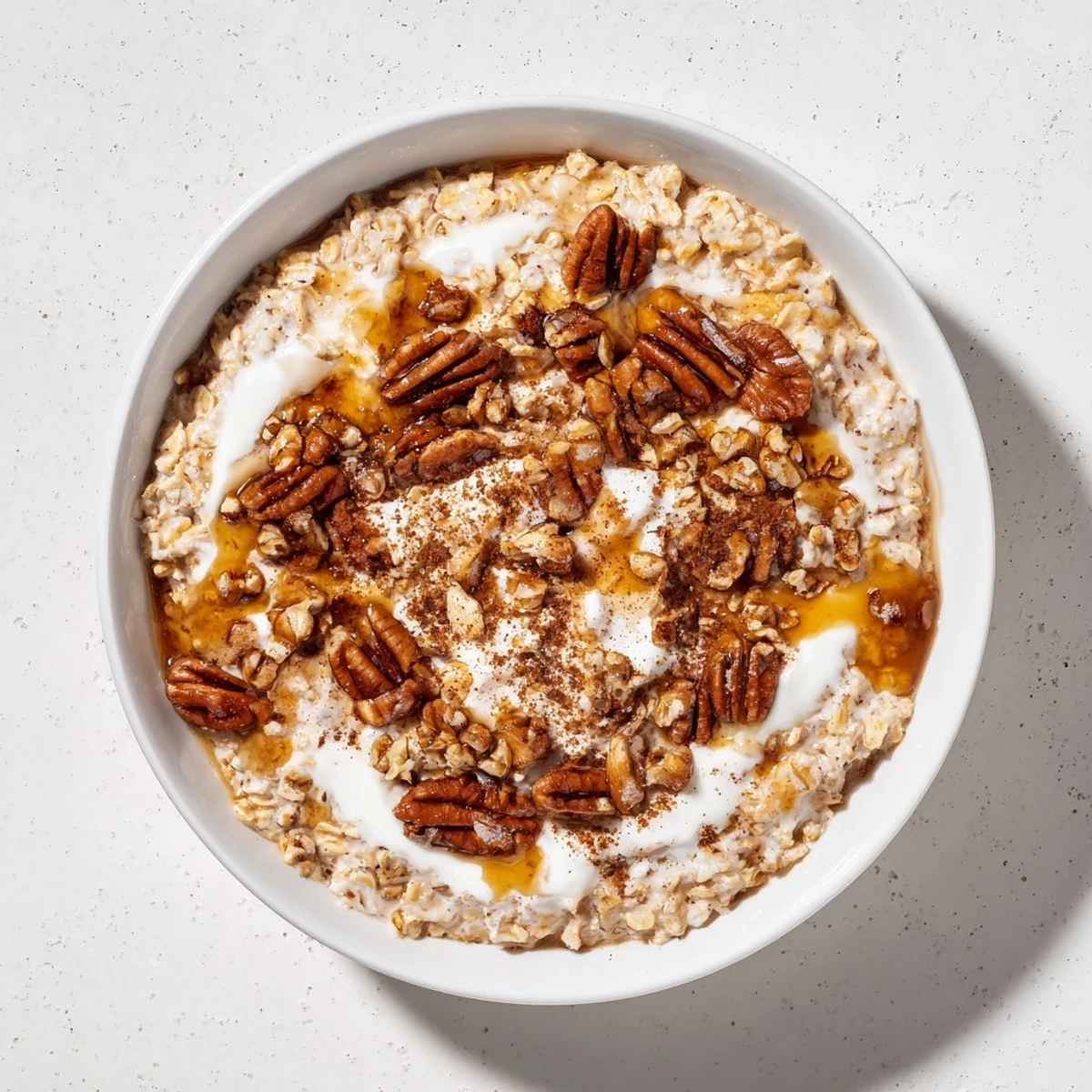 Steaming bowl of Pumpkin Spice Latte Oats, topped with whipped cream and chopped pecans.