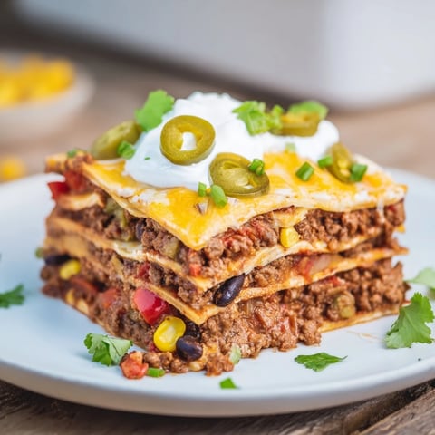 A bubbling, cheesy Taco Lasagna layered with seasoned meat, veggies, and creamy cheeses, ready to serve.