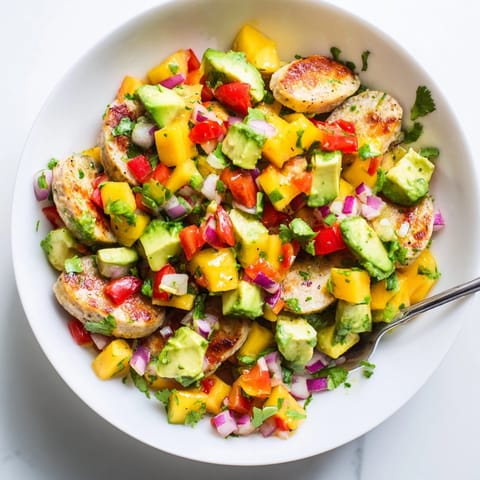 Close-up reveals chunks of sweet mango in creamy Mango Avocado Salsa with Sausage.