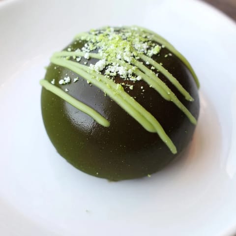 Vibrant green Matcha Dark Chocolate Peppermint Truffles, a delicious sweet treat dusted with matcha and served after chilling.