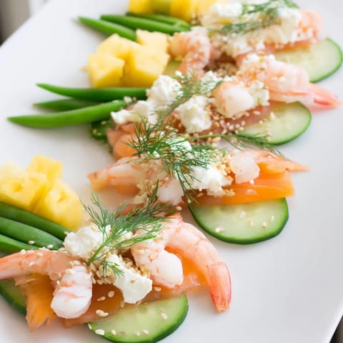 A colorful Wave Rider Surfer Snack Board filled with fresh seafood and vibrant fruits.