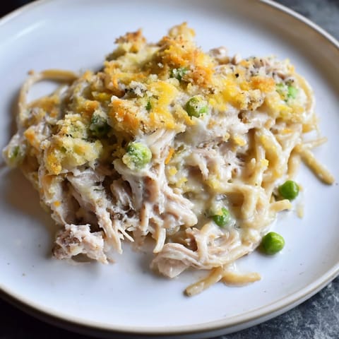Creamy Turkey Tetrazzini bake, a savory pasta dish filled with tender turkey and green peas.
