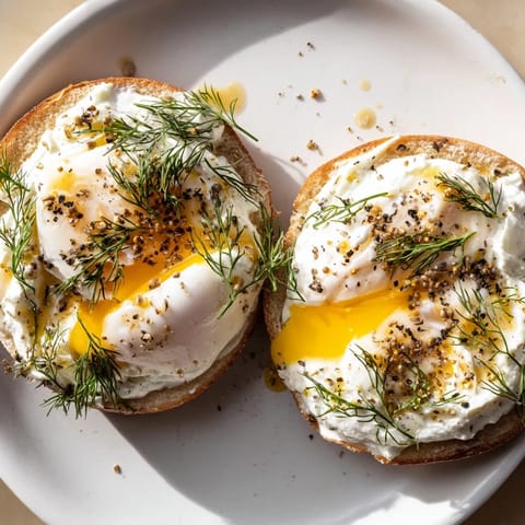 A beautiful plate of Çılbır Eggs Benedict shows vibrant yolks and fresh herbs, ready to enjoy.