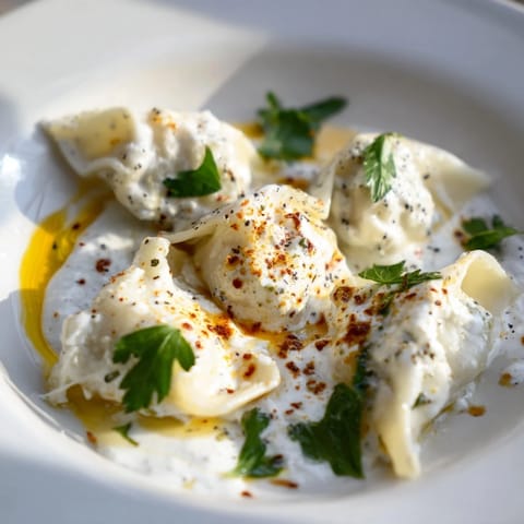 A close-up of golden-brown Turkish Cheesy Manti on a plate, boasting a creamy cheese filling.