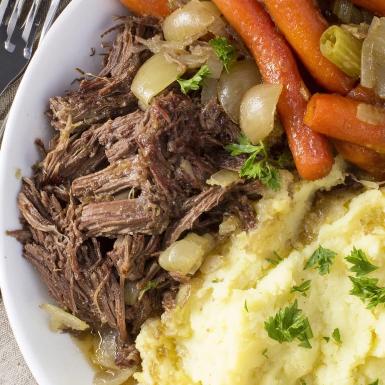 Savory slow cooker pot roast paired with buttery mashed potatoes and delicious pan juices.