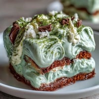Elegant matcha tiramisu with creamy mascarpone and matcha-soaked ladyfingers, dusted with vibrant green tea powder.